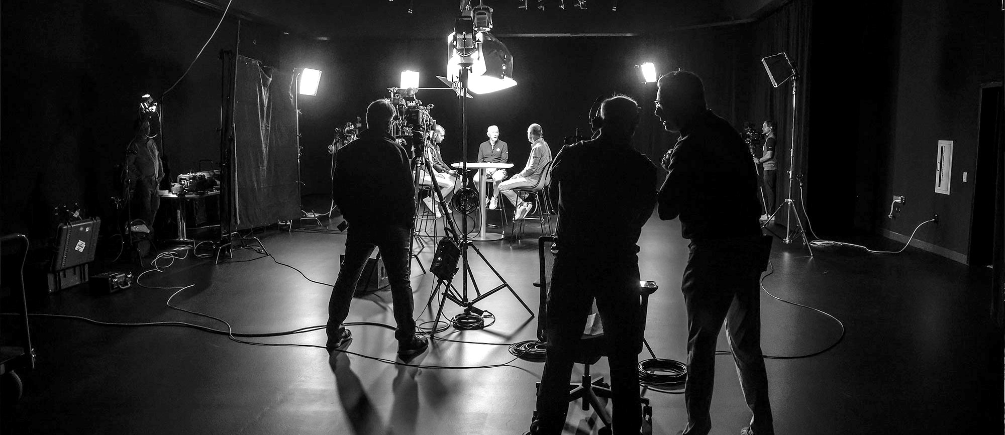 Crew filming an interview at a round table in a professional studio
