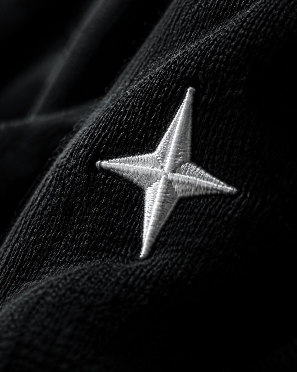 White four-point star embroidered on black fabric