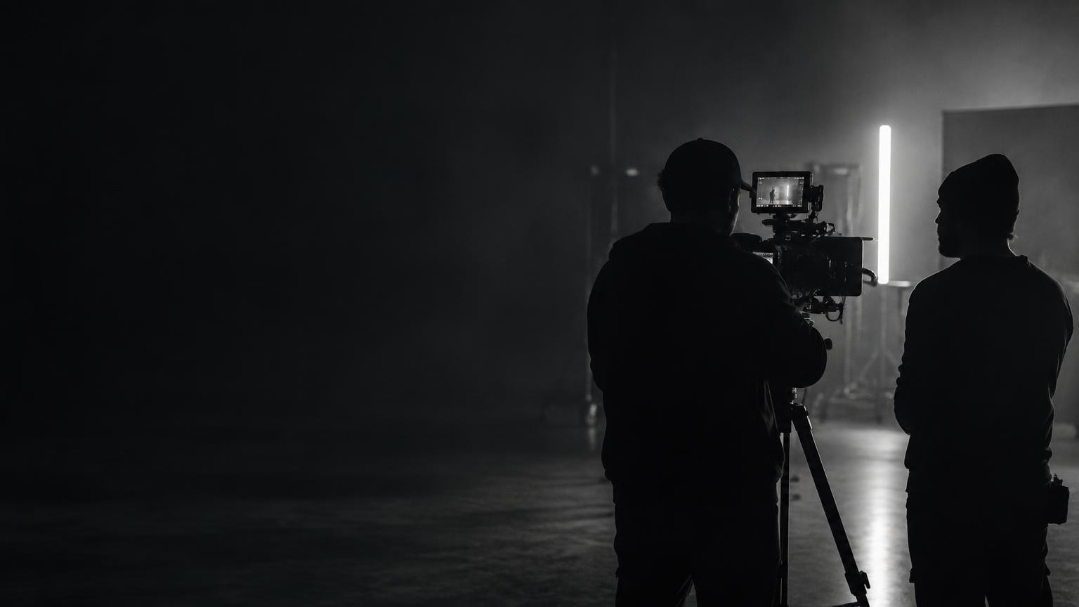Film crew working with a cinema camera on a dark set